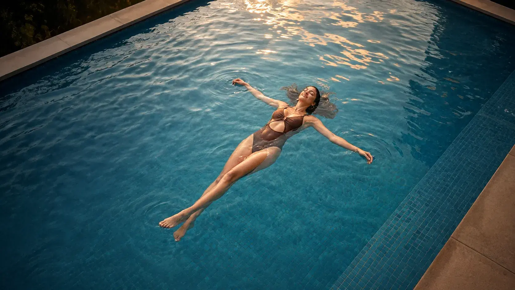 Mulher boiando na piscina do Aruna Patamares