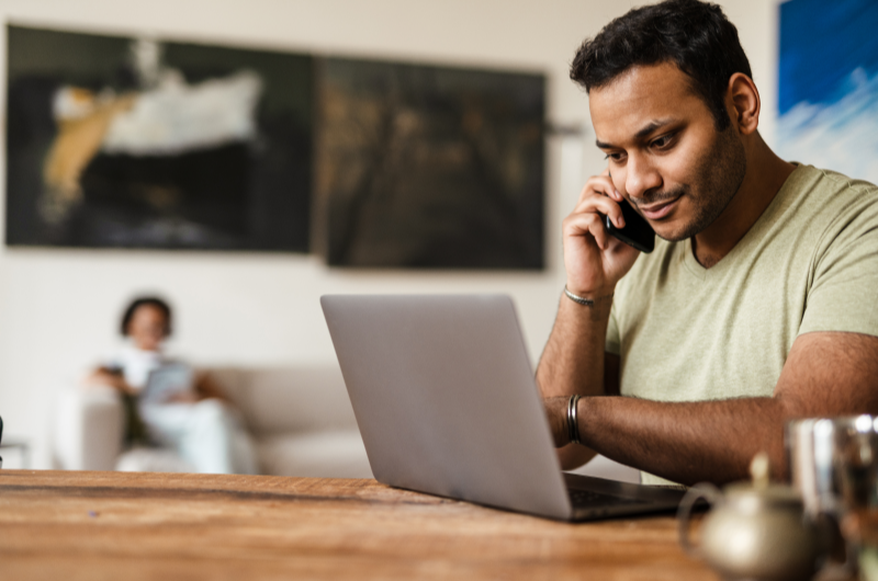 Não consultar o score de crédito | Homem usando o notebook e falando no celular | Trilha da Conquista | Blog da Tenda