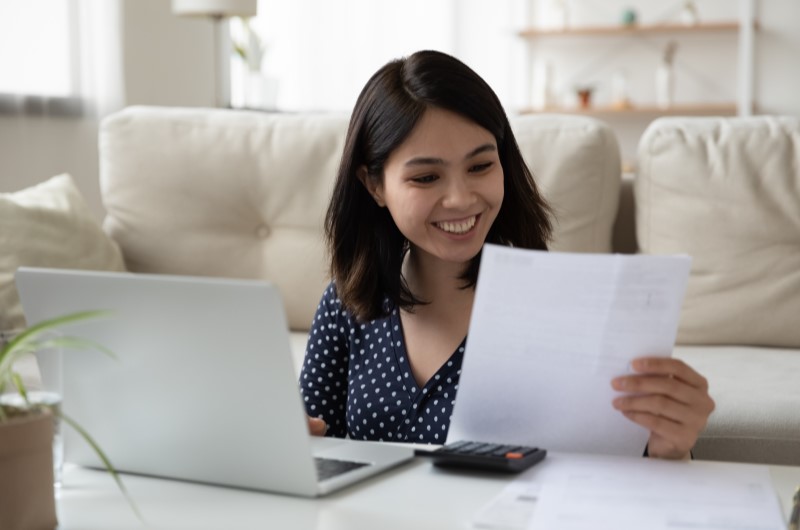 Como ser um afiliado de sucesso | Foto de uma mulher feliz olhando para um papel | Economia e renda extra | Eu Dou Conta