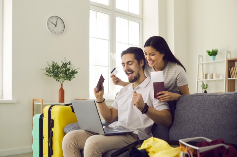 Exemplos de metas financeiras | Foto de um casal sorridente olhando para o notebook | Economia e renda extra | Eu Dou Conta