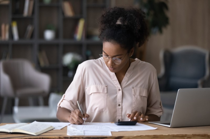 Mulher fazendo contas | Dicas para sair das dívidas até o final do ano | Dúvidas sobre dívidas