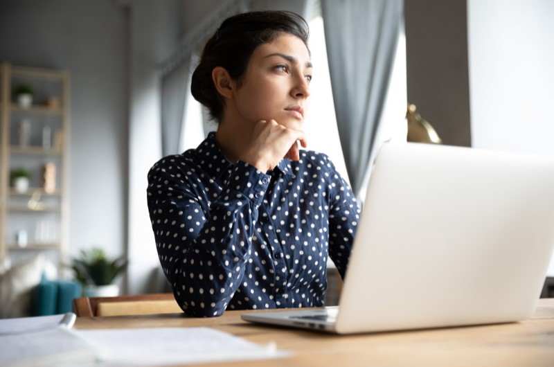 Mulher preocupada mexendo no computador | É possível conseguir um financiamento para negativado | Como limpar o nome | Eu Dou Conta