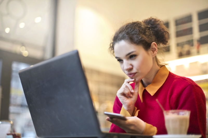 E-commerce com programa de afiliados | Foto de uma mulher pensativa olhando para o notebook | Economia e renda extra | Eu Dou Conta