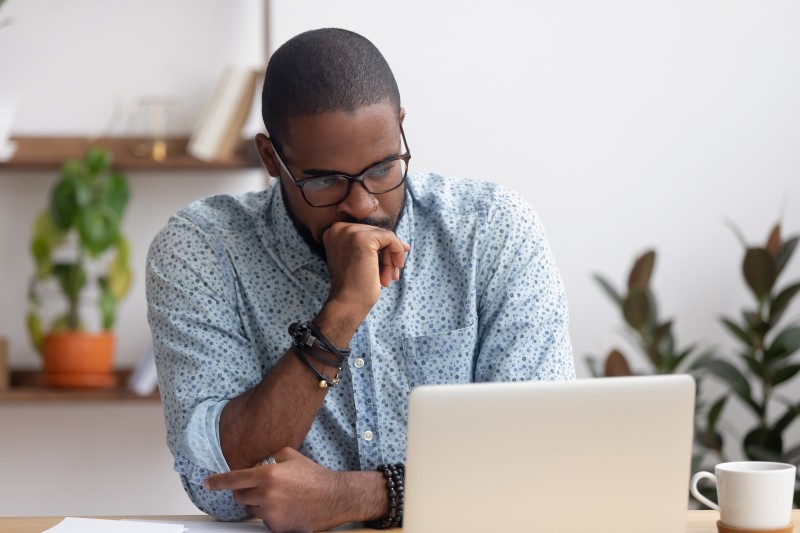 Como saber se o nome está sujo | Foto de um homem preocupado na frente do computador | Dúvidas sobre dívidas | Eu Dou Conta