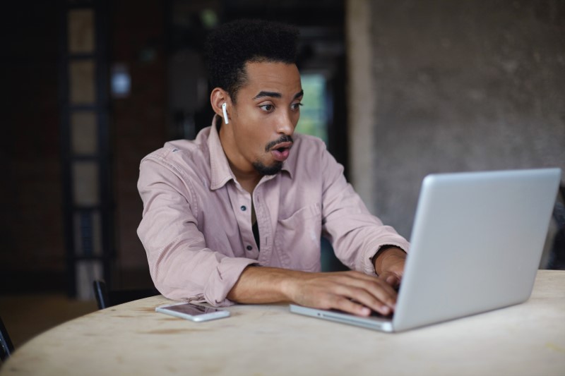 Como funciona o Feirão Limpa Nome Serasa | Foto de um homem impressionado na frente do computador | Dúvidas sobre dívidas | Eu Dou Conta