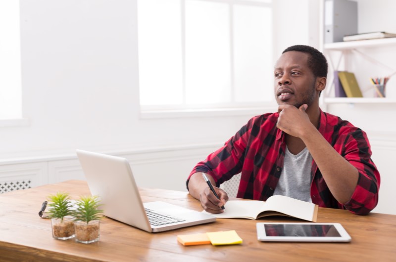 Como evitar gastos desnecessários | Foto de um homem com dúvidas pesquisando no computador | Economia e renda extra | Eu dou Conta