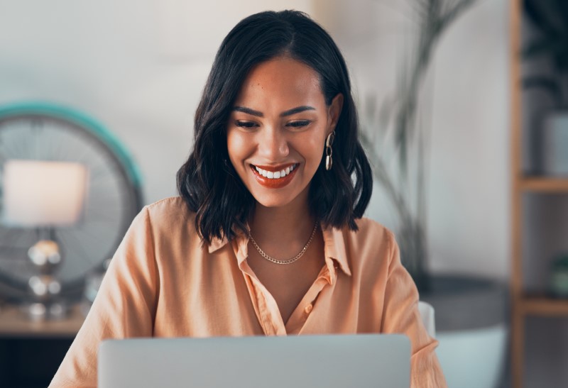 Como funciona o programa de afiliados | Foto de uma mulher feliz pesquisando na internet | Economia e renda extra | Eu Dou Conta