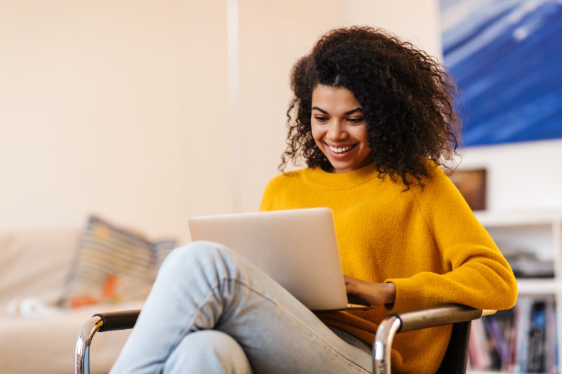 Quais as vantagens dos programas de afiliados | Foto de uma moça feliz pesquisando na internet | Economia e renda extra | Eu Dou Conta