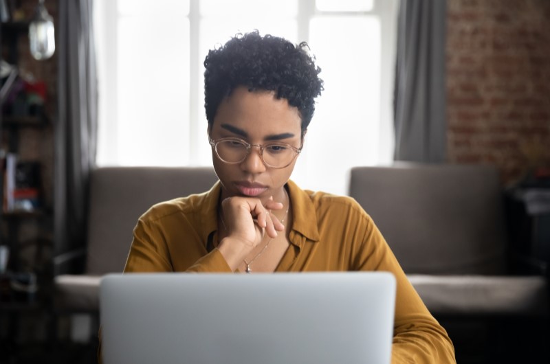 Qual o melhor tipo de financiamento | Foto de um mulher concentrada no notebook | Dúvidas sobre dívidas | Eu Dou Conta 