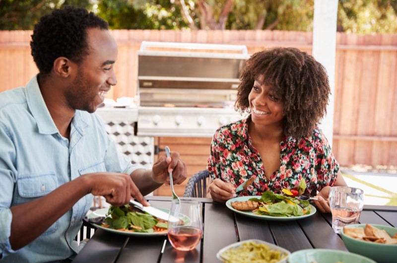 Como economizar na alimentação? | Foto de um casal sorridente fazendo uma refeição | Economia e renda extra | Eu Dou Conta 