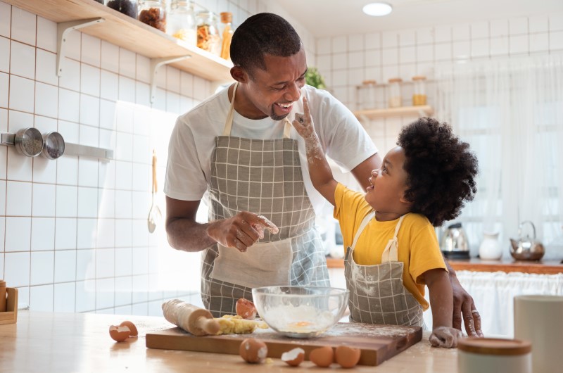 Cozinhe algum prato com as crianças | Foto de um pai e filho se divertindo na cozinha enquanto cozinham | Economia e renda extra | Eu Dou Conta