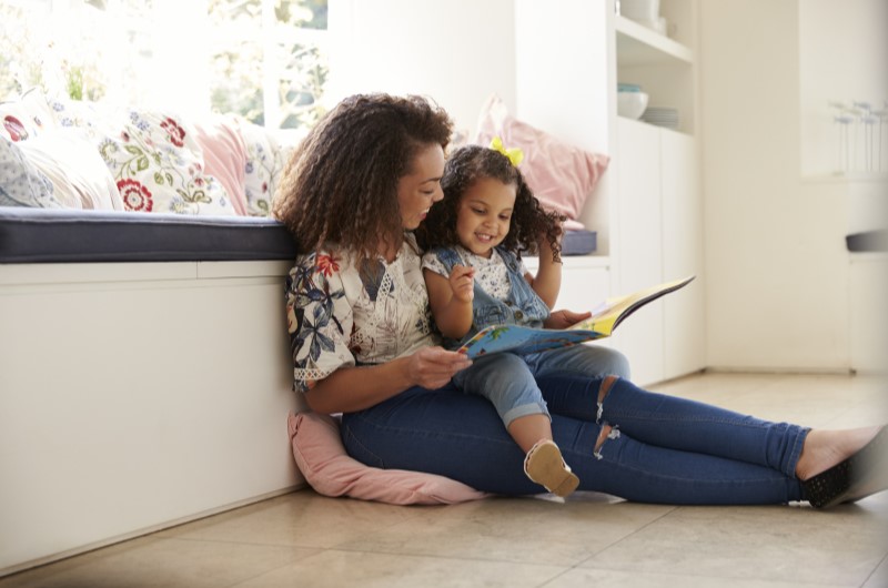 Quando começam as férias escolares? | Foto de uma mãe e filha sentadas enquanto leem uma livro | Economia e renda extra | Eu Dou Conta 