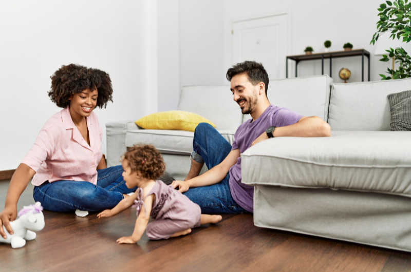 Como escolher o bairro ideal para a sua família? | Foto de uma família feliz na sala de estar | Trilha da Conquista | Blog da Tenda