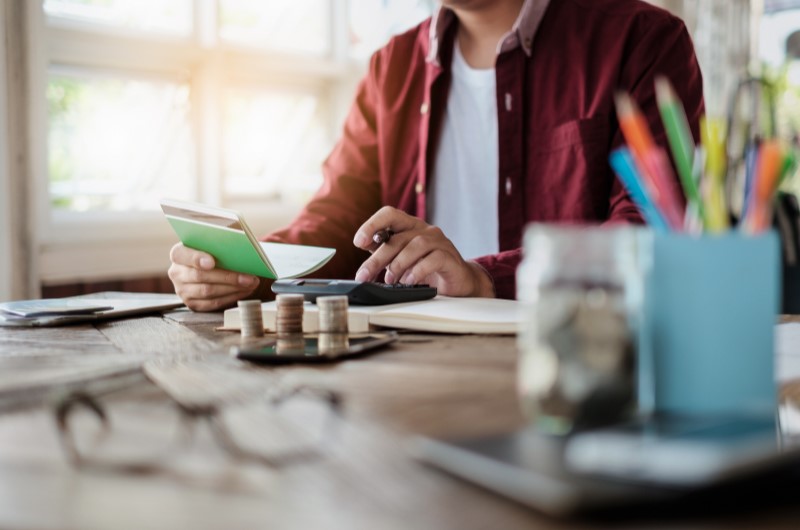 Faça um controle financeiro | Foto de uma pessoa fazendo contas com uma calculadora | Economia e renda extra | Eu Dou Conta 