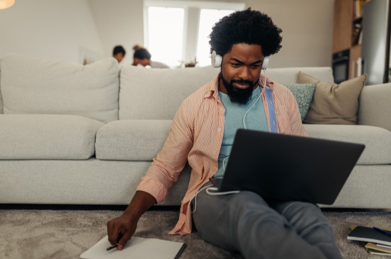 Renegocie suas dívidas | Foto de um homem com um caderno e notebook na sala | Economia e renda extra | Eu Dou Conta 