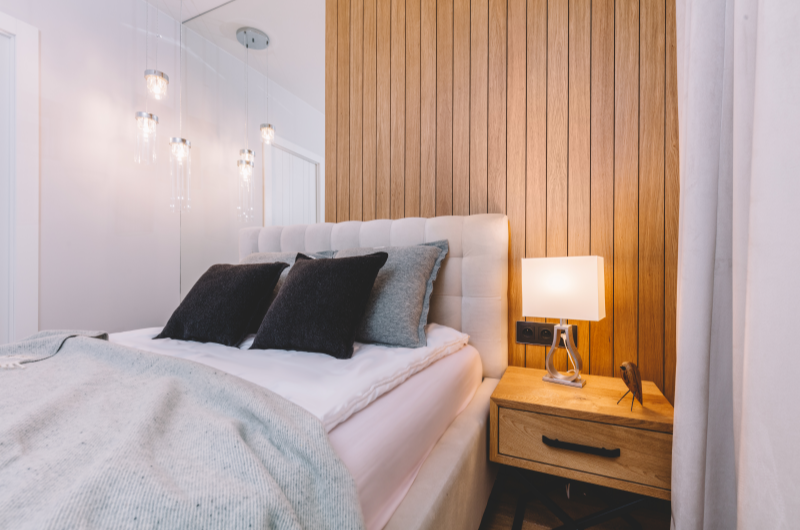 10 dicas de decoração para quarto de apartamento pequeno | Foto de um quarto de casal decorado em branco, preto, cinza e com detalhes em madeira | Casa e Decoração | Blog da Tenda