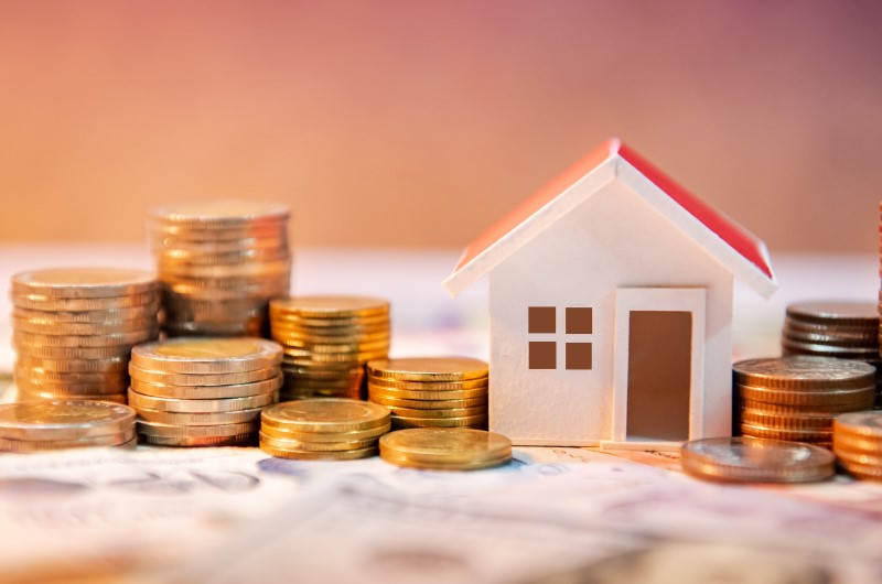 O que é o subsídio Minha Casa, Minha Vida 2024? | Foto de uma casinha rodeada de moedas | Minha Casa Minha Vida | Blog da Tenda