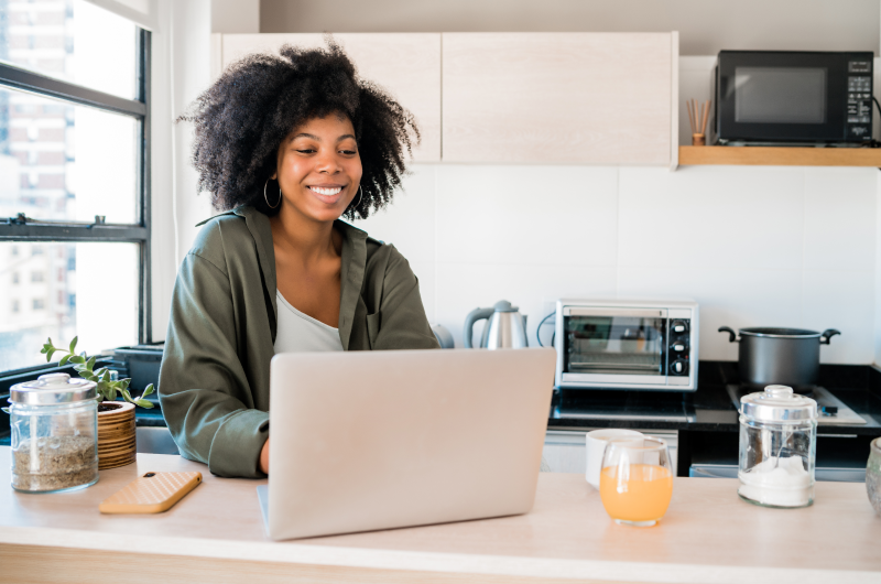 O que fazer no bairro do Limão e na Zona Norte de São Paulo? | Foto de uma mulher sorridente usando o notebook | Trilha da Conquista | Blog da Tenda