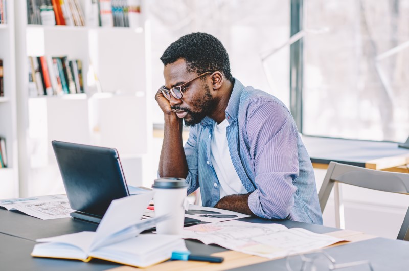 Como saber se você está com restrição de crédito? | Foto de um homem concentrado usando o notebook | Como limpar o seu nome | Eu Dou Conta 