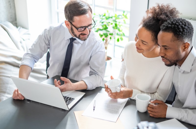 Como solicitar um crédito imobiliário? | Foto de um casal conversando com um corretor | Trilha da Conquista | Blog da Tenda