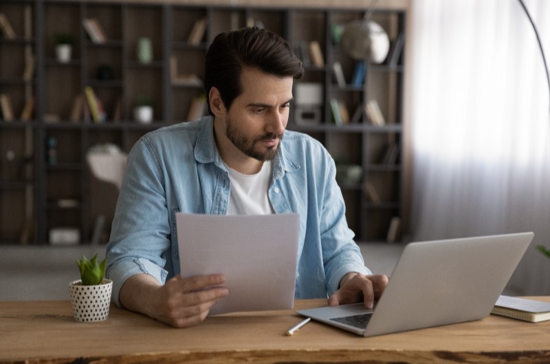 Como aplicar o método 50, 30, 20? | Foto de uma mulher organizando as finanças com um caderno, um notebook e uma calculadora | Economias e renda extra | Eu Dou Conta 