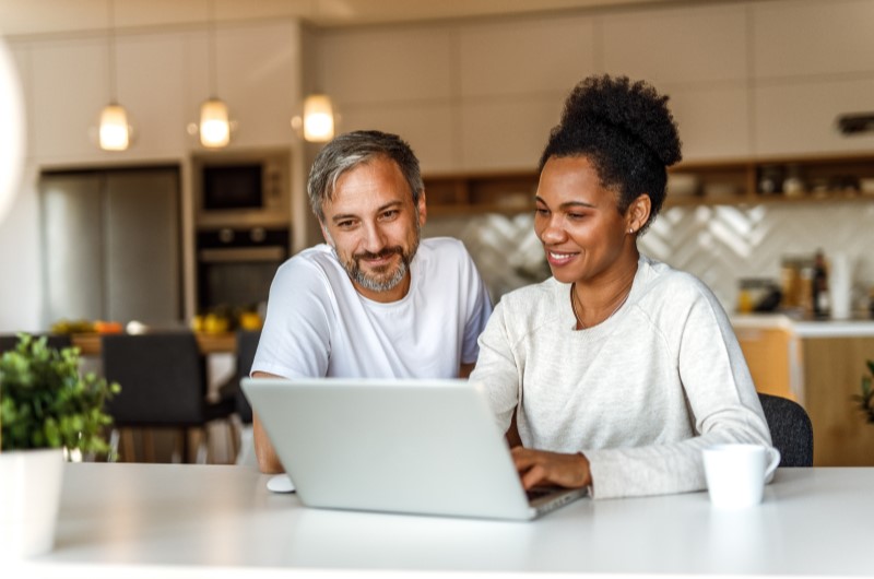 Facilidade na contratação | Foto de um casal utilizando o notebook | Dúvidas sobre dívidas | Eu Dou Conta