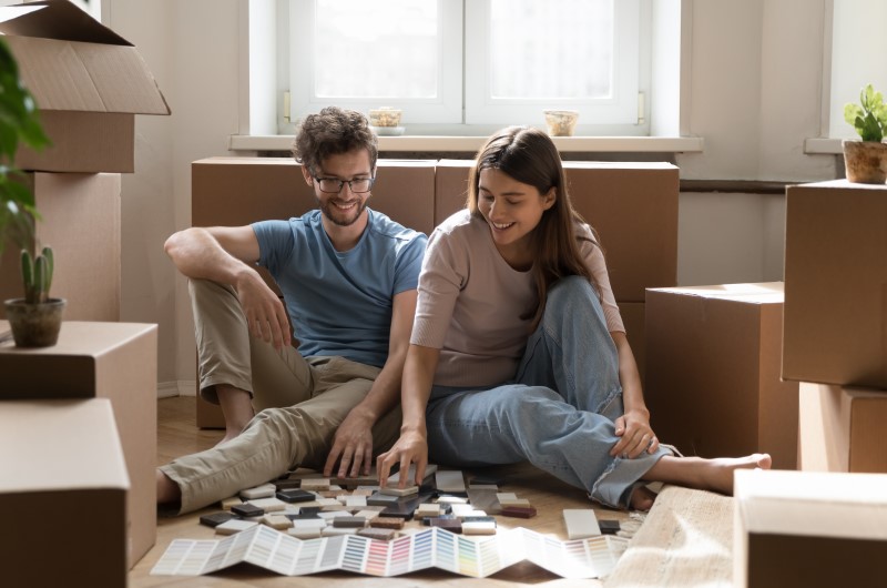 Qual o piso de apartamento ideal para cada ambiente | Foto de um casal sorridente olhando amostras de diversos tipos de piso para apartamento | Casa e decoração | Blog da Tenda