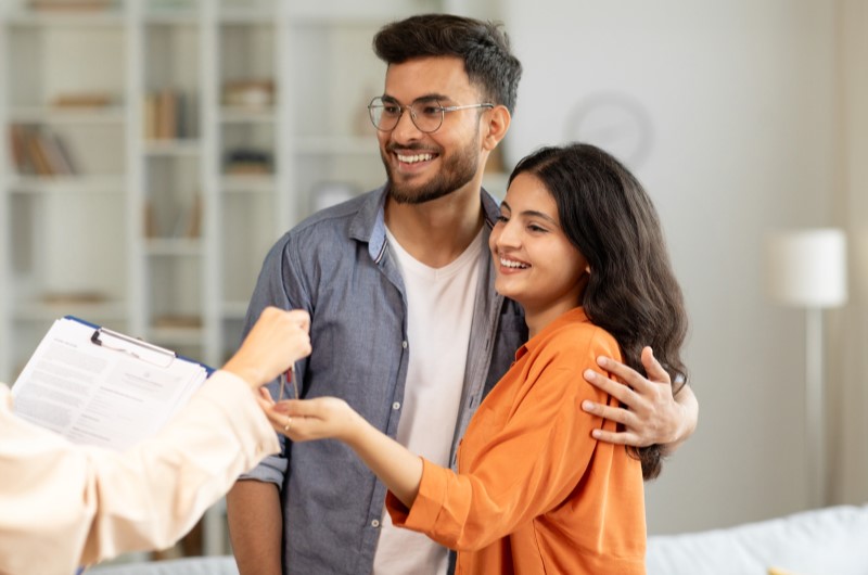 7 dicas essenciais e cuidados na hora de comprar um imóvel | Casal sorridente recebendo a chave da casa própria | Casa e decoração | Blog da Tenda