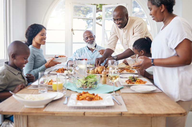 Tipos de mesa posta | Foto de uma família feliz ao redor de uma mesa posta | Casa e Decoração | Blog da Tenda