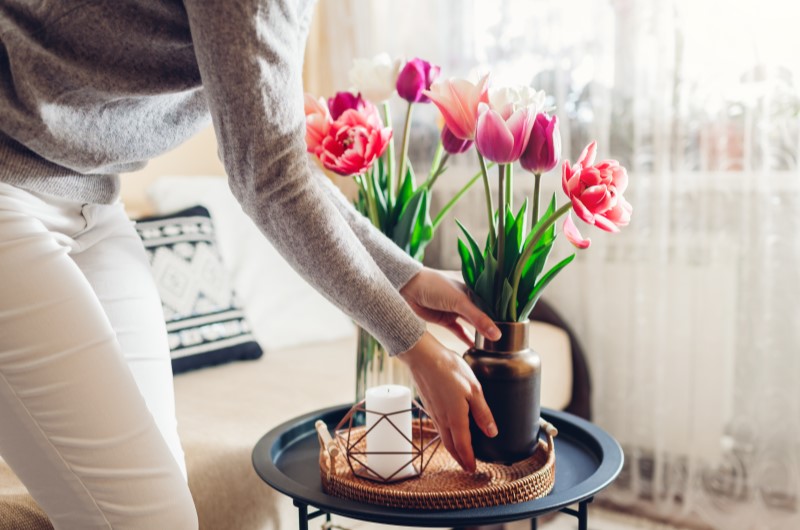 Quando a Primavera Começa? | Mulher colocando um arranjo de flores sobre a mesa | Casa e Decoração | Blog da Tenda