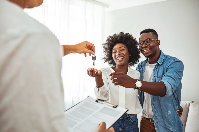 Quanto custa um apartamento da Tenda? | Casal sorridente recebendo a chave da casa própria de um corretor | Trilha da Conquista | Blog da Tenda