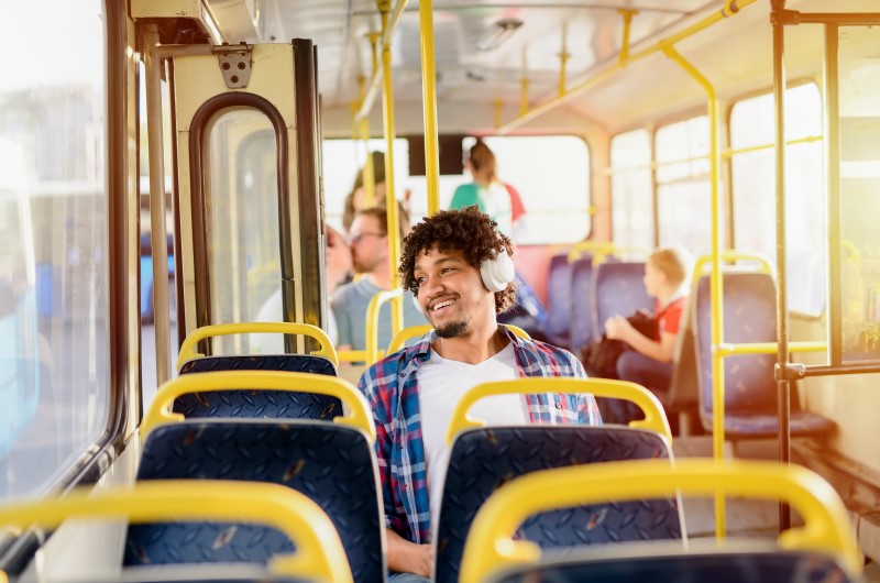 Transporte na Zona Oeste do Rio de Janeiro | Homem sorridente e sentado no ônibus | Trilha da Conquista | Blog da Tenda