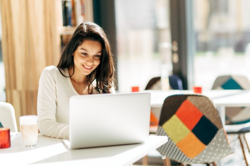 Achei um imóvel por conta própria, como proceder? | Mulher sorridente usando o notebook | Blog da Tenda 