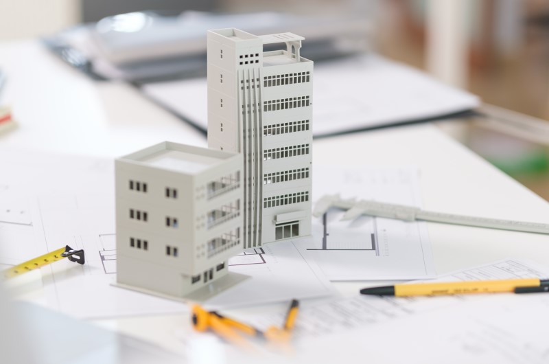 O que é um imóvel na planta | Miniatura de prédio sobre um planta baixa residencial | Trilha da Conquista | Blog da Tenda 