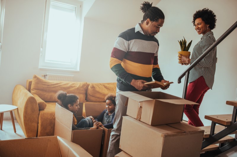 Como organizar mudança para apartamento | Família organizando caixas de mudança em casa, com crianças brincando nas caixas | Viver em Condomínio | Blog da Tenda 