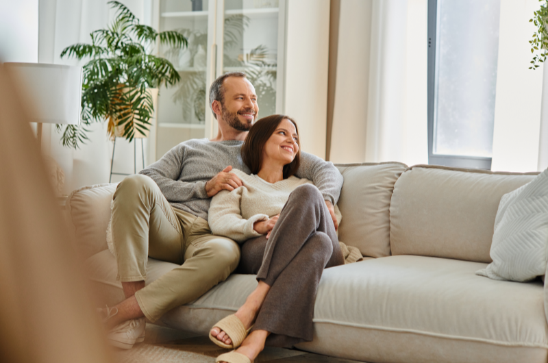 Como é morar em Campinas | Casal relaxando juntos em um sofá em ambiente aconchegante | Onde morar | Blog da Tenda