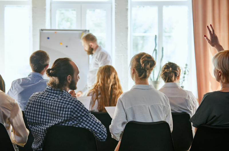 Como fazer uma reunião de condomínio produtiva | Condôminos reunidos assistindo a uma apresentação durante reunião de condomínio | Viver em Condomínio | Blog da Tenda 