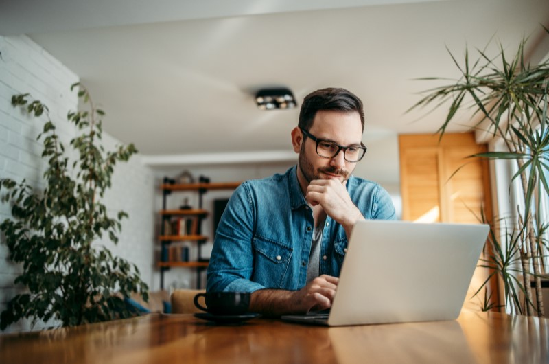 Como funciona a tabela SAC | Homem concentrado usando notebook em ambiente aconchegante | Trilha da Conquista | Blog da Tenda 