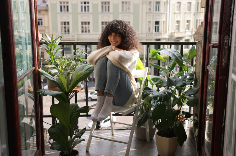 Plantas | Mulher sentada em uma cadeira cercada por vasos de plantas | Casa e Decoração | Blog da Tenda 