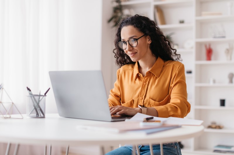 Uso do FGTS | Mulher trabalhando no laptop em um ambiente iluminado | Blog da Tenda 