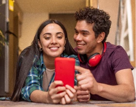 Imagem de um casal sorrindo e pesquisando algo na internet | Como funciona o consórcio imobiliário | Tenda Consórcio | Tenda.com