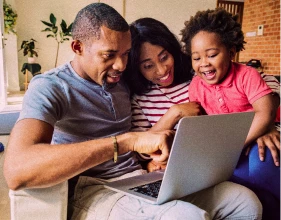 Imagem de uma família usando um notebook | Consórcio imobiliário vale a pena | Tenda Consórcio | Tenda.com
