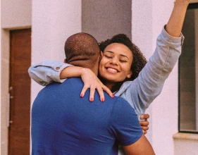 Imagem de um casal celebrando uma conquista | Como fazer um consórcio imobiliário | Consórcio Tenda | Tenda.com