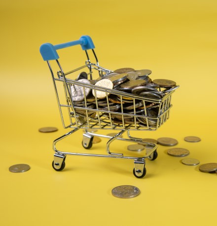 Planejamento alimentar: como economizar na alimentação em 2024 | Foto de um mini carrinho de mercado com moedas | Economia e renda extra | Eu Dou Conta