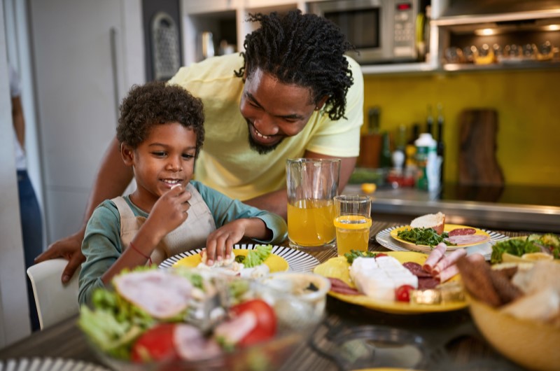 Qual a importância da alimentação saudável? | Foto de um pai e filho na cozinha, aproveitando uma refeição saudável | Economia e renda extra | Eu Dou Conta 