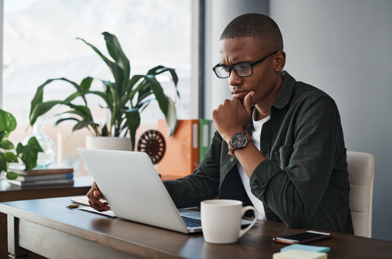 O que é empréstimo para CLT? | Foto de um homem com a expressão seria olhando para o notebook | Dúvidas sobre dívidas | Eu Dou Conta