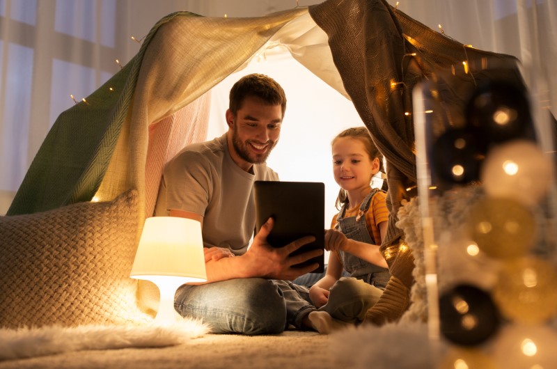 Presente para o Dia dos Pais: caseiro |Foto de um pai e filha lendo um livro em uma cabana dentro de casa | Economia e renda extra | Eu Dou Conta