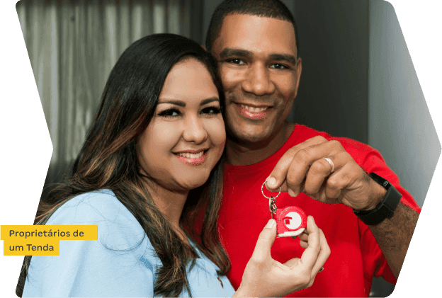 Casal feliz segurando chave do novo apartamento comprado online com a Tenda